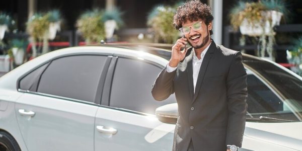 curly-haired-indian-businessman-talking-phone-front-car_496169-2836.jpg